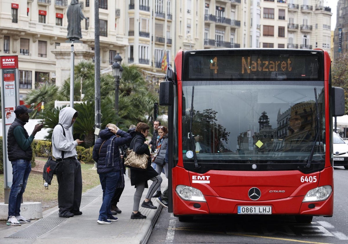 Varias personas suben al autobús en una parada del centro de la ciudad.