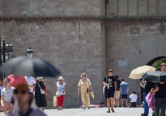 Personas con parasol en Valencia.
