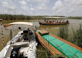 Una embarcación de recreo cruza ante la zodiac donde el equipo de Medio Ambiente monitoriza el estado del fondo de la laguna.