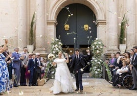 Alberto y Paula, a la salida de la ceremonia eclesiástica, recibidos con una lluvia de claveles.
