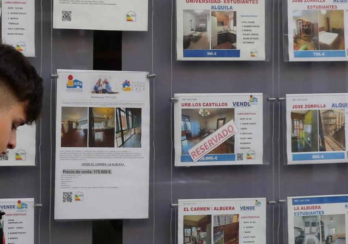 Un joven pasa por delante de una inmobiliaria, en una imagen de archivo.