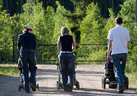 Tres padres pasean con sus hijos.