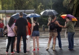 Varias personas se protegen de la lluvia en Valencia.
