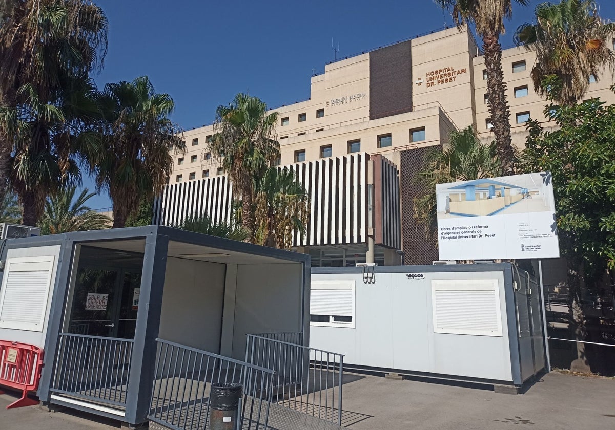 Cartel con el anuncio de la obra junto al barracón en el hospital Peset.