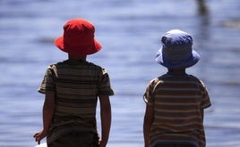 Dos niños de espaldas mirando el mar