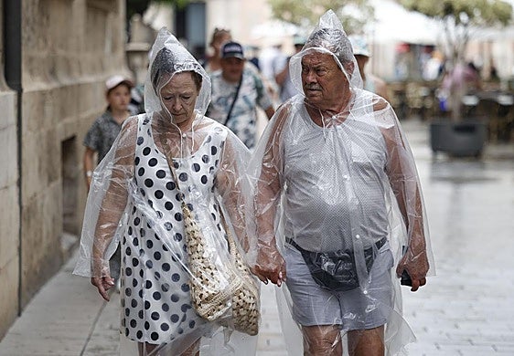 Dos personas se protegen de la lluvia.
