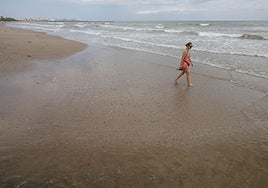 Mujer que pasea por la orilla de Port Saplaya.