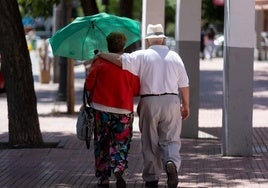 Una pareja de jubilados caminan por la calle.