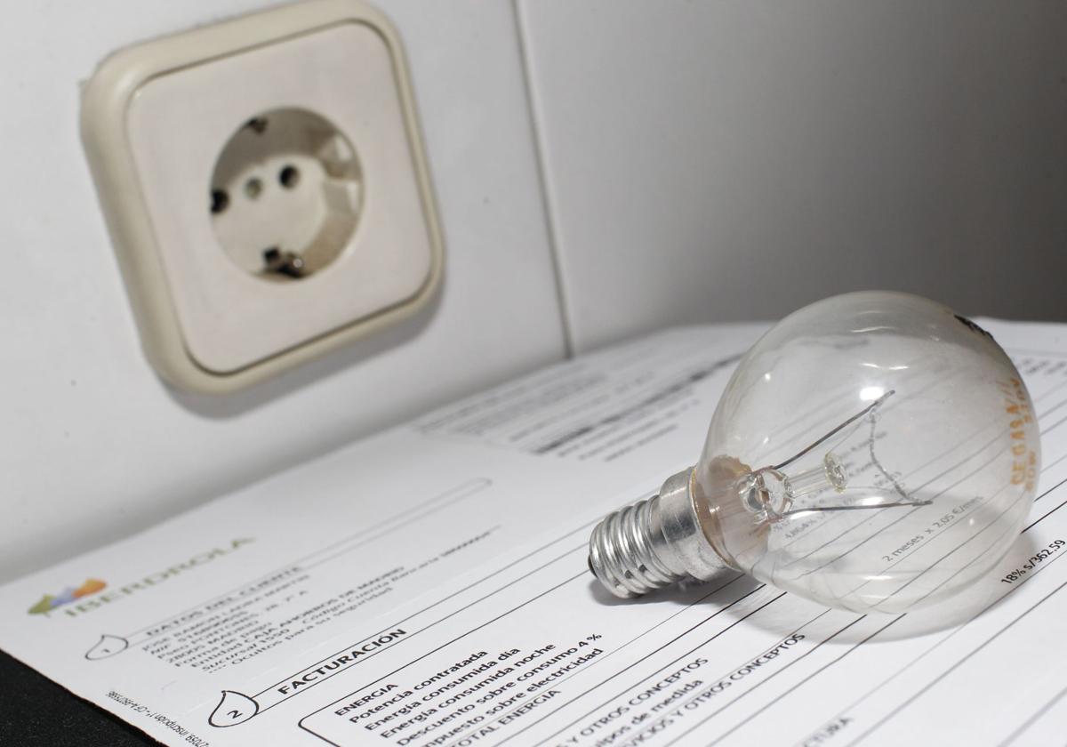 Factura de la luz junto a una bombilla.