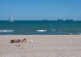 Dos mujeres toman el sol en la playa.
