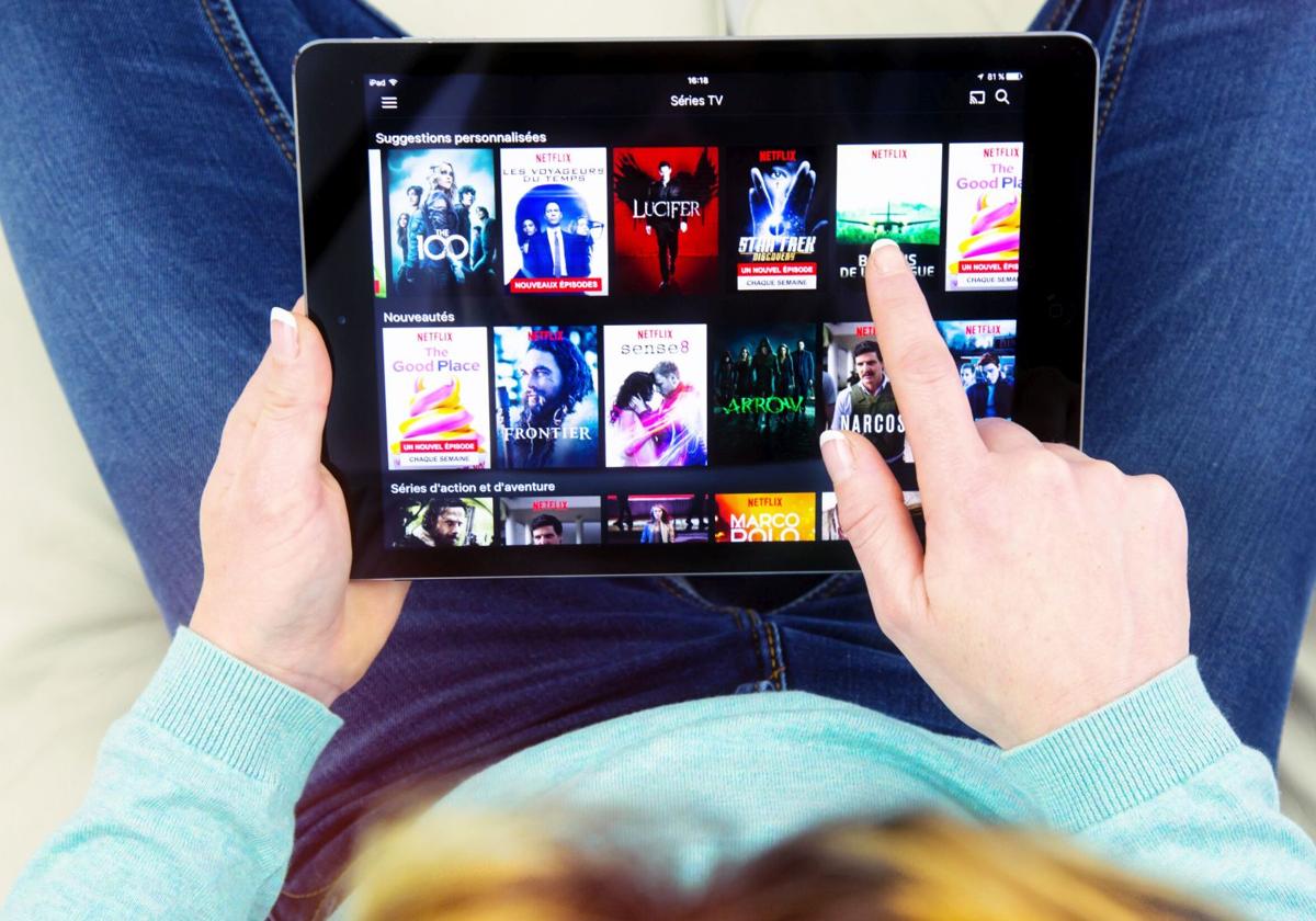 Una mujer utiliza Netflix en su tablet.