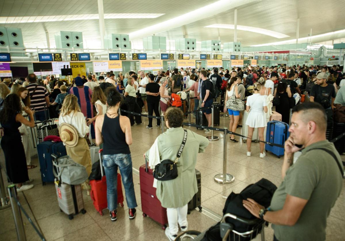 Un grupo de personas hacen cola en el aeropuerto de El Prat.