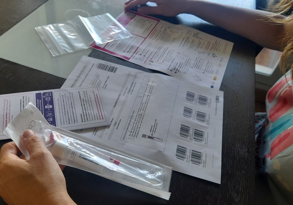 Una destinataria del autotest vaginal revisa el material e instrucciones que Sanidad le ha mandado por correo.