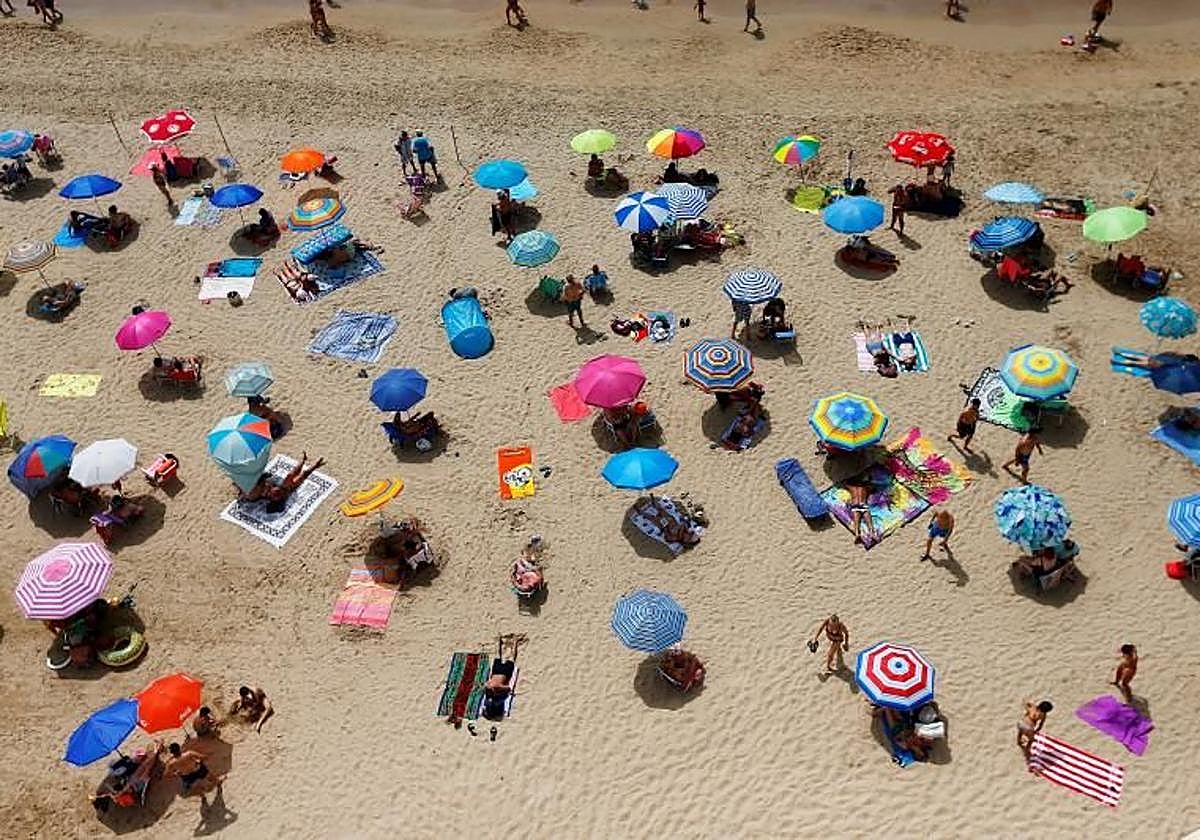 Decenas de turistas disfrutan del sol y la playa en Benidorm.