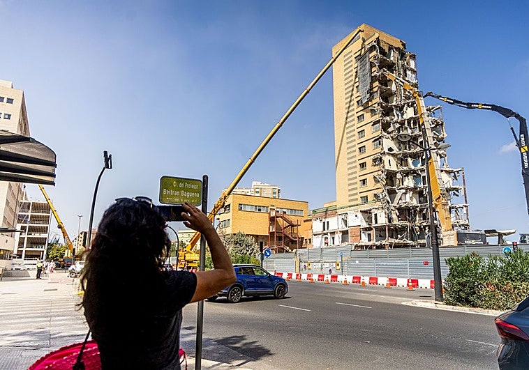 Una mujer fotografía la demolición del edificio de Maternal.