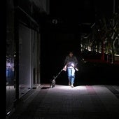 Una mujer pasea a su perro durante el apagón.