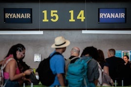 Turistas hacen cola en un mostrador de la aerolínea Ryanair.