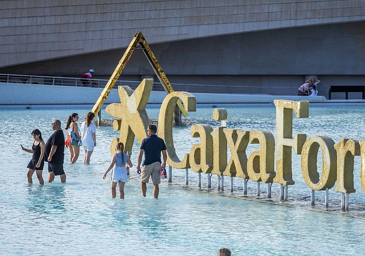 Lago del Ágora del complejo de la Ciudad de las Artes y las Ciencias, con gente bañándose y paseando.
