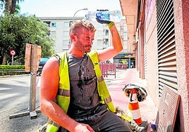 Un obrero refrescándose con una botella de agua este lunes.