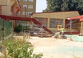 Un operario coloca vallas alrededor del techado del colegio Lluís Vives de Massanassa.