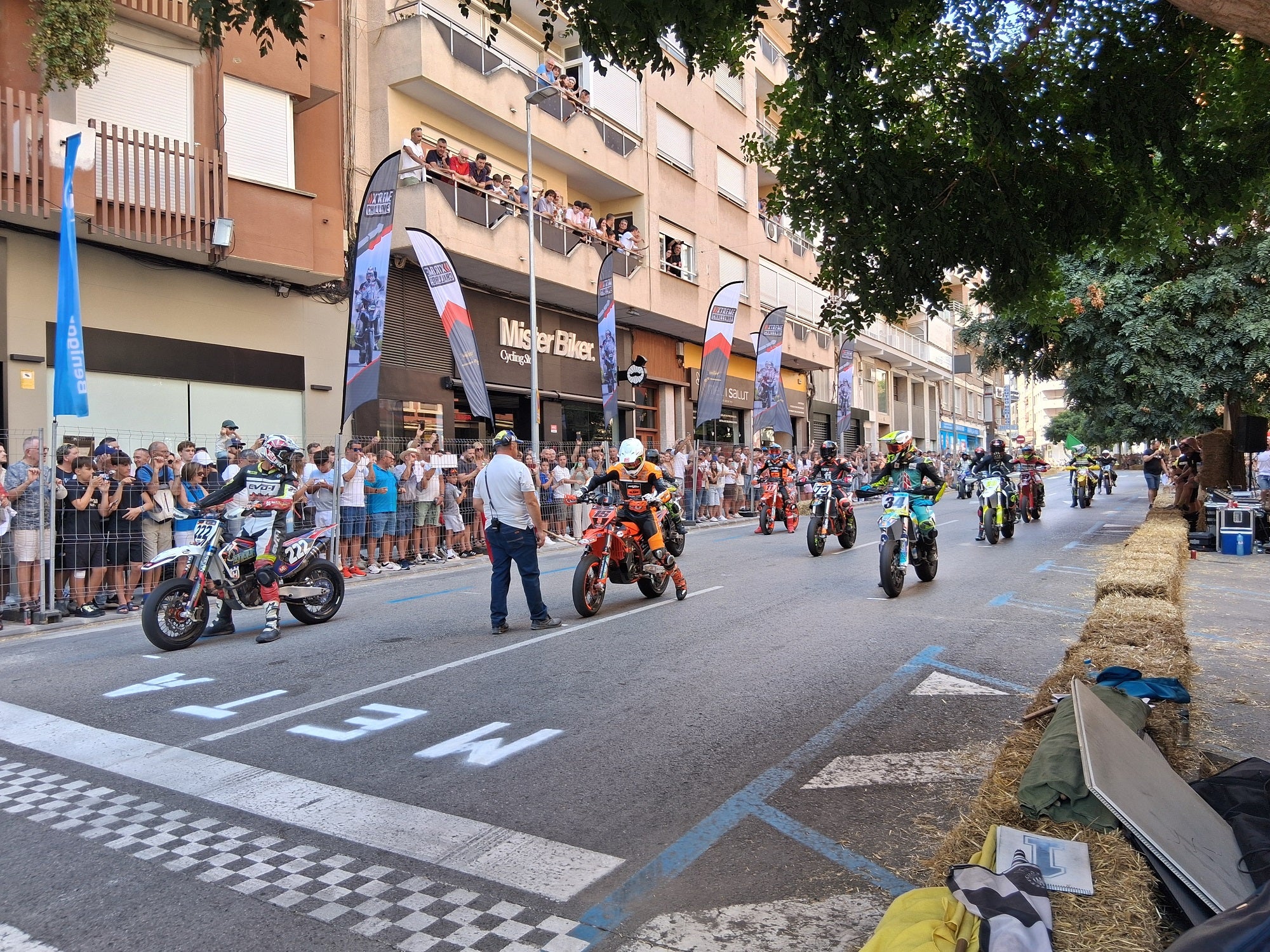 Los pilotos preparados en la salida para iniciar la carrera. Abajo, un hombre refresca a su caballo en la Fira al Bestiar.