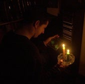 Un hombre se alumbra con unas velas.