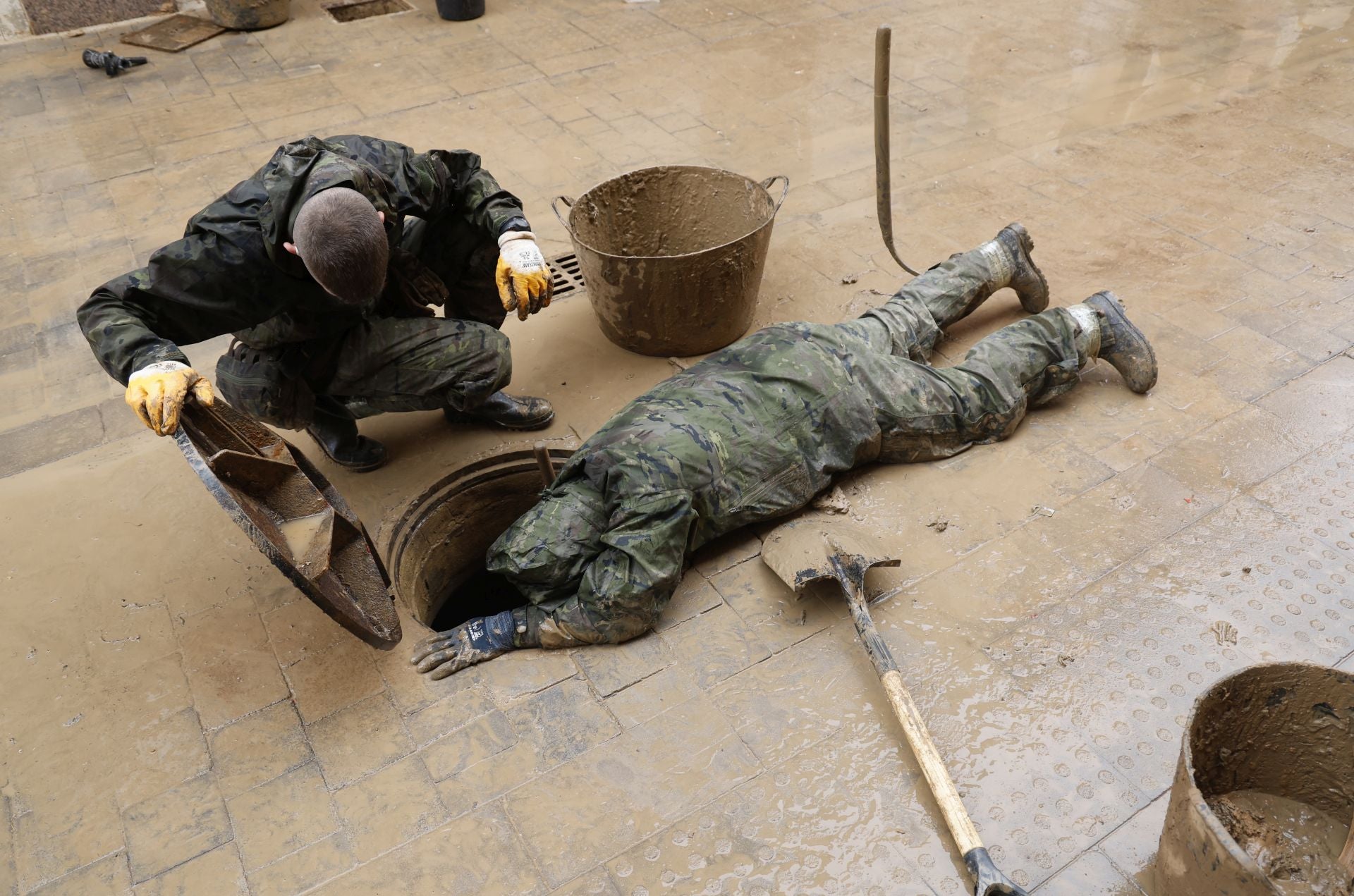 Retiran lodo de una alcantarilla en Paiporta tras la dana.
