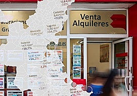 Viandantes pasan por el escaparate de una inmobiliaria.