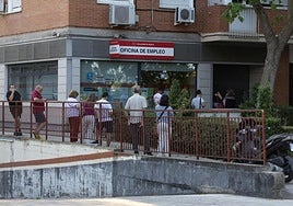 Varias perrsonas hacen cola en una oficina del SEPE.