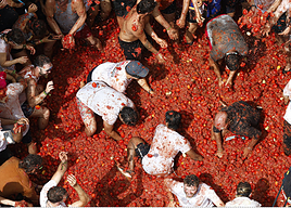 Participantes en la Tomatina se lanzan tomates en un momento de la celebración.