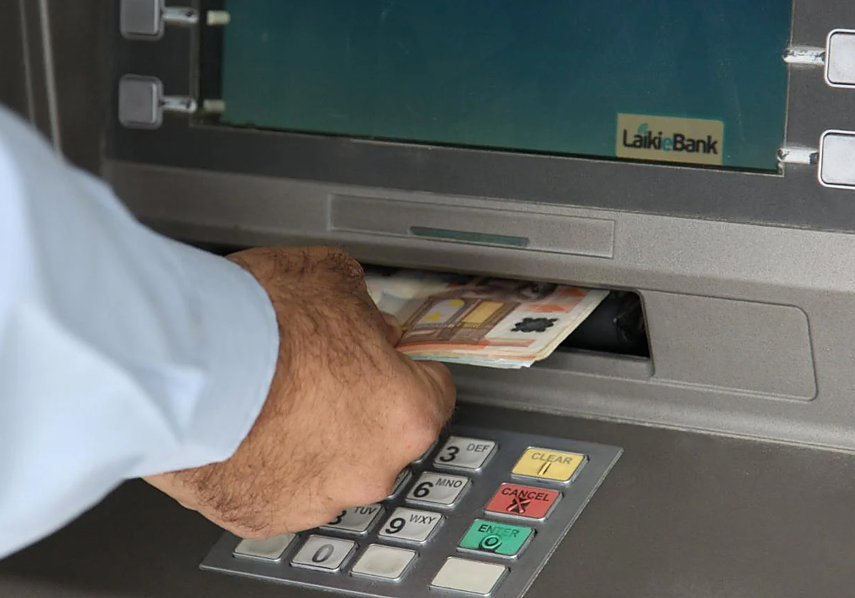 Un usuario saca dinero de un cajero.