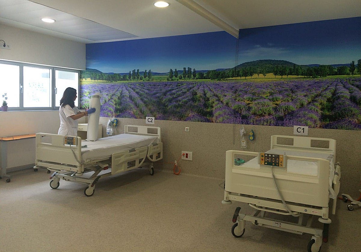 Una enfermera arregla una cama del hospital.