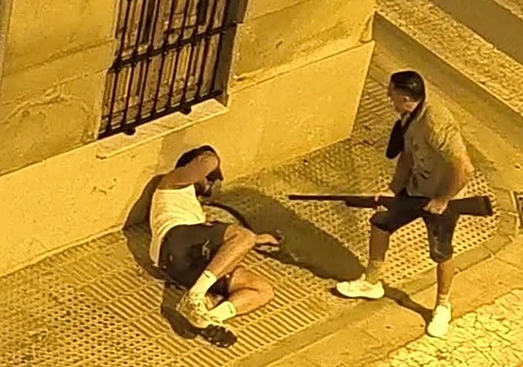 El presunto autor de los disparos con la escopeta todavía en las manos y su víctima en el suelo.