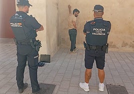 Dos policías custodian al presunto ladrón junto al muro de las atarazanas del Grao.