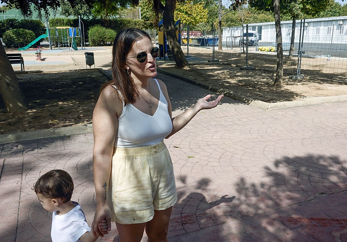 Una madre con su hijo junto a los barracones de Massanassa, todavía en obras a falta de cuatro días.