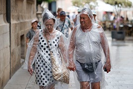 Dos personas se protegen de la lluvia en una imagen de archivo.