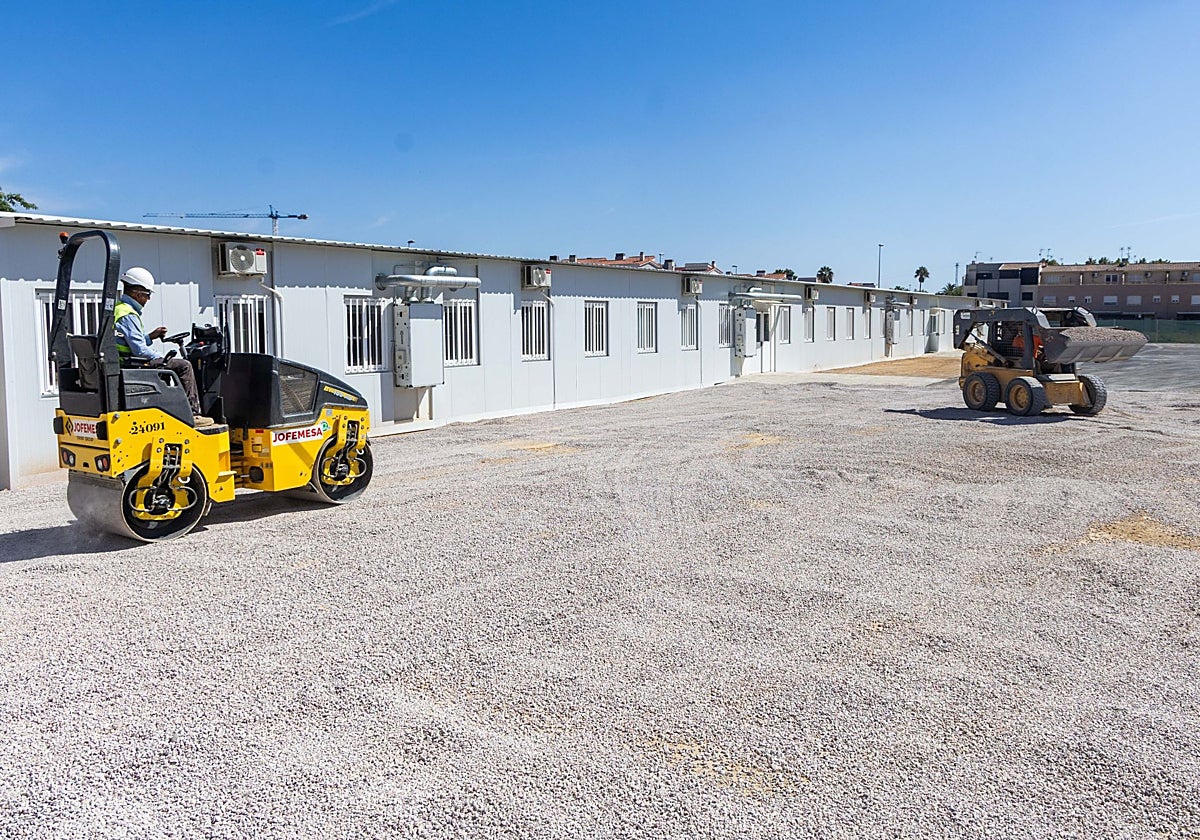 Operarios trabajando en la explanada del patio de Primaria del colegio Orba de Alfafar.