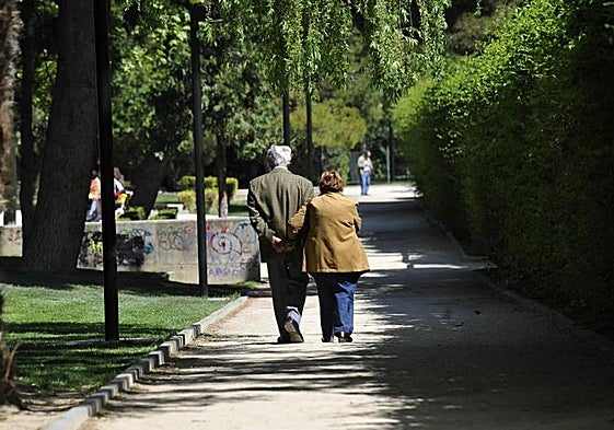 Una pareja de pensionistas pasea por un parque, en una imagen de archivo.