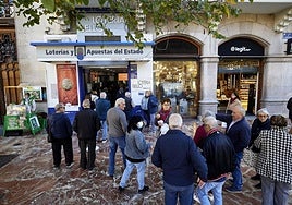 Varios jugadores de Lotería Nacional hacen cola para comprar su décimo, imagen de archivo.