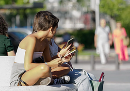 Dos adolescentes en la puerta de un instituto.