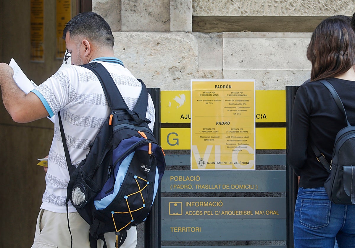 Dos personas esperan su turno en las oficinas del padrón del Ayuntamiento de Valencia.
