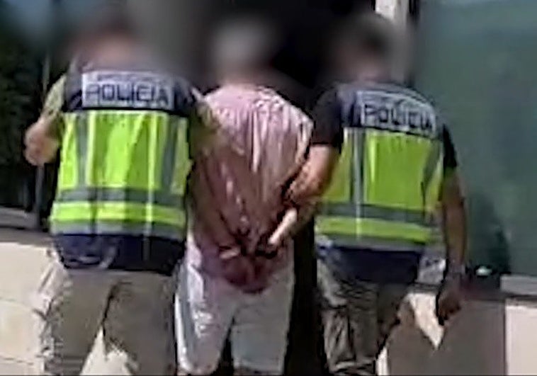 Dos policías trasladan al detenido a dependencias policiales.