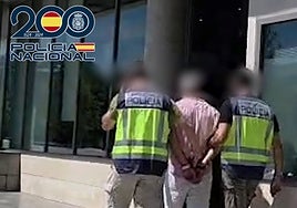 Dos policías trasladan al detenido a dependencias policiales.
