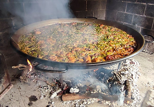 La paella valenciana reposa sobre las brasas.