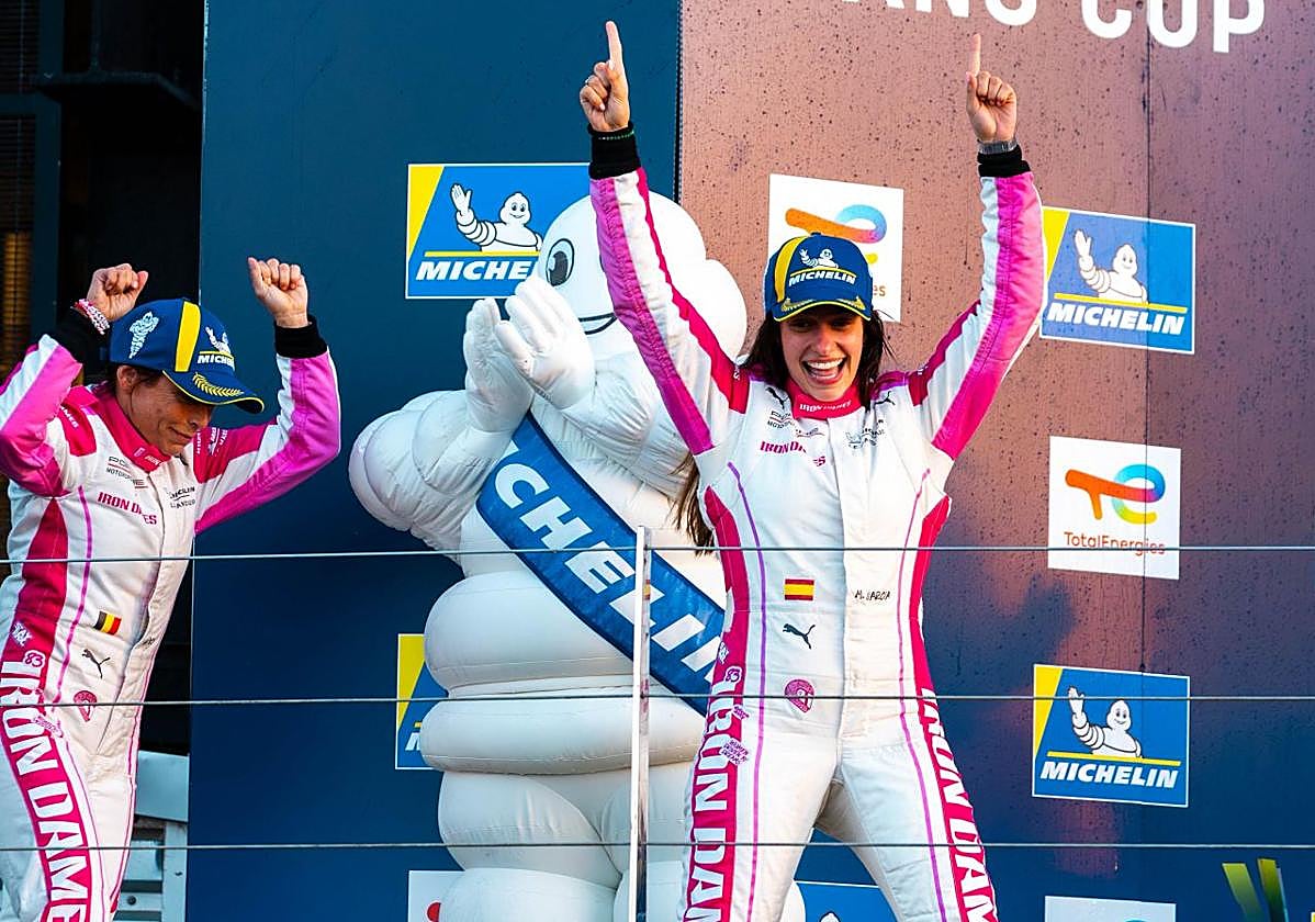 Marta García alza los brazos en el podio junto a su compañera, Vanina Ickx.