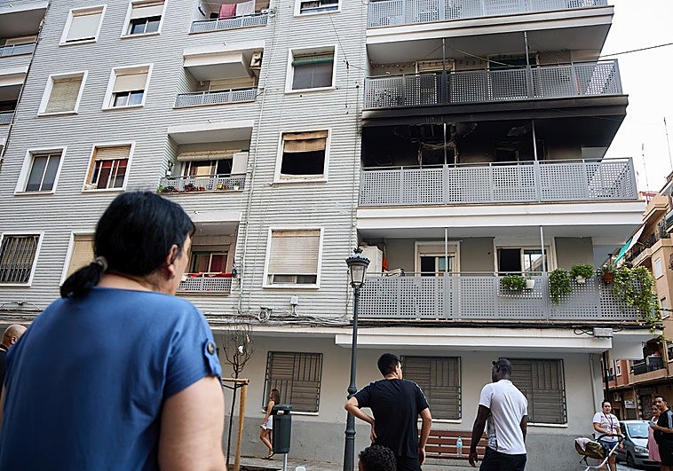 Unos vecinos observan los destrozos que causó el incendio en esta finca de la calle Padre Viñas.