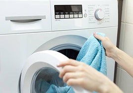 Una persona pone una lavadora.