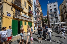 Turistas transitan por la puerta de la antigua ferretería, que abrirá en octubre como supermercado.