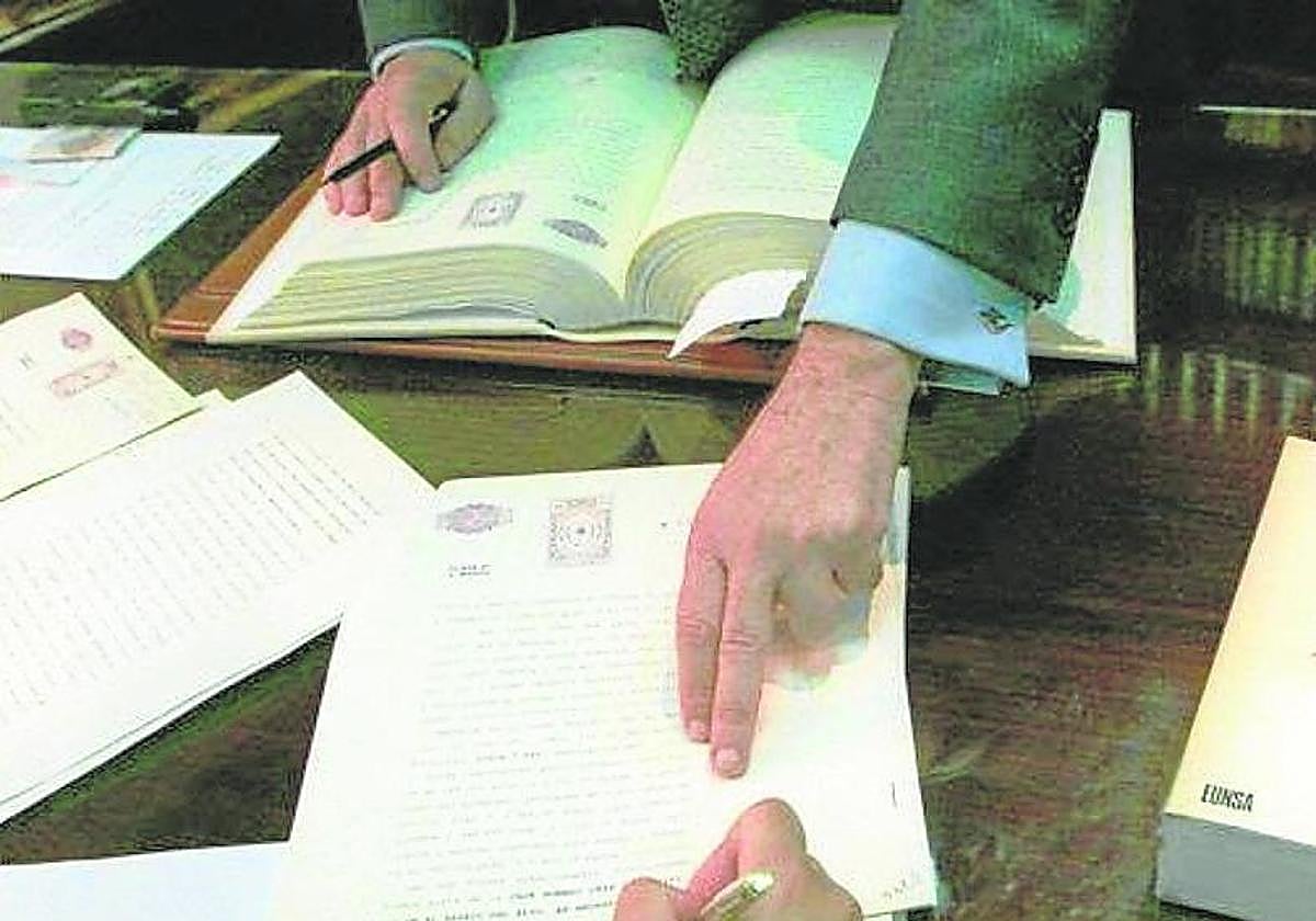 Firma de una escritura en el despacho de un notario, en una imagen de archivo.