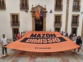 Los representantes de Compromís desplegando la lona que pide la dimisión de Mazón.